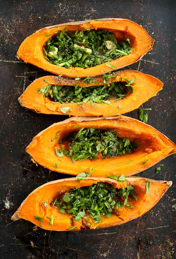 Step 2 of preparing Baked Eggs with Spinach in sweet potato boats--spinach and butter added