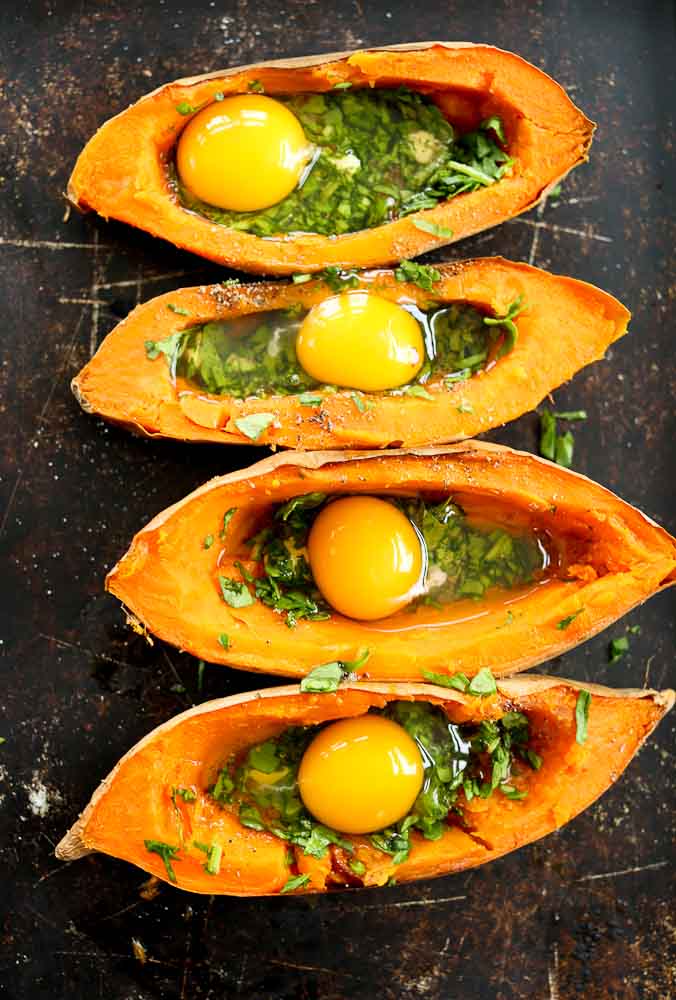 Step 3 of preparing Baked Eggs with Spinach in sweet potato boats--raw eggs added