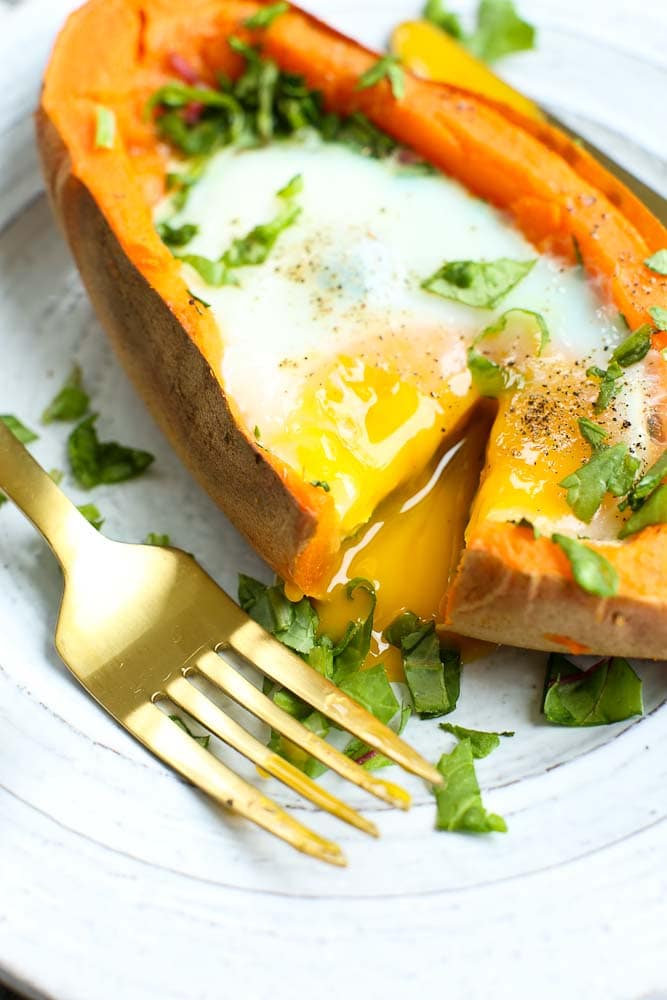 Runny yolk baked egg with spinach stuffed inside a sweet potato