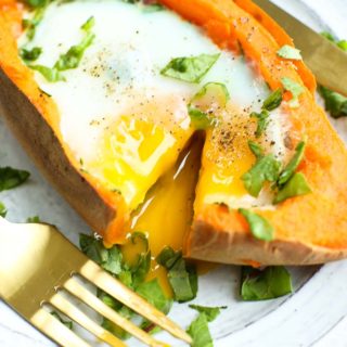 Runny yolk baked egg with spinach stuffed inside a sweet potato