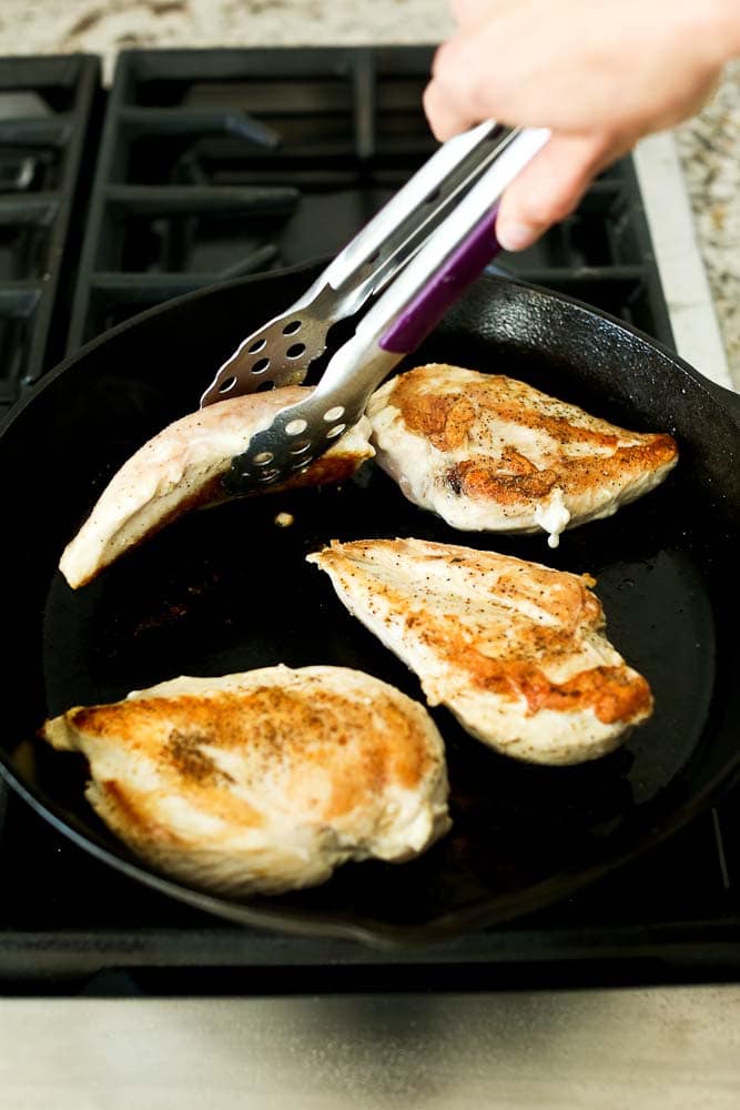 Browning the chicken breasts on the stove top in the cast iron skillet
