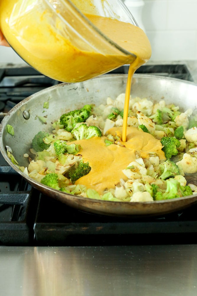 Sauce being poured over vegetables for Vegetable Pumpkin Curry Recipe