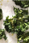 crispy kale on a white board with drops of oil