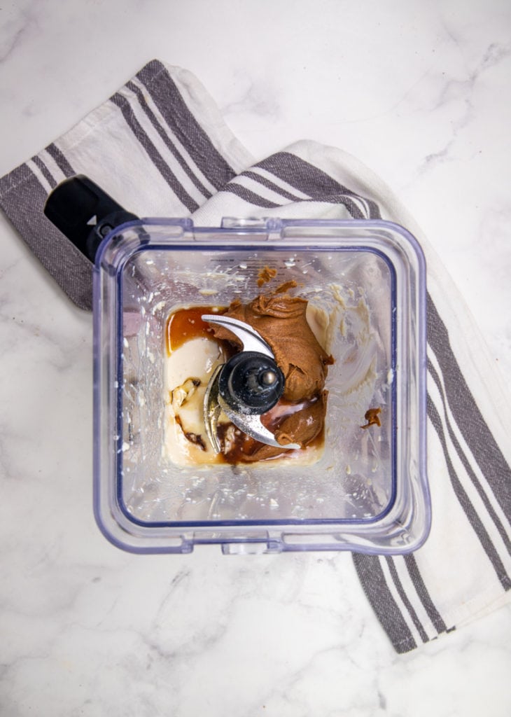 adding more ingredients to the top of the blender