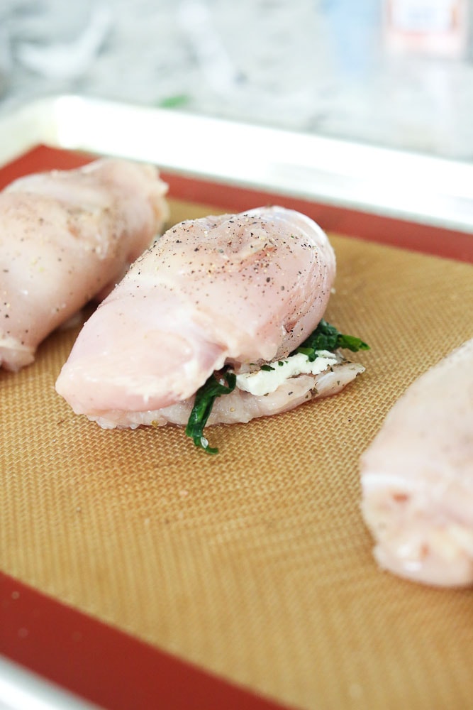 Spinach and Goat Cheese Stuffed Chicken Breast rolled up on baking sheet
