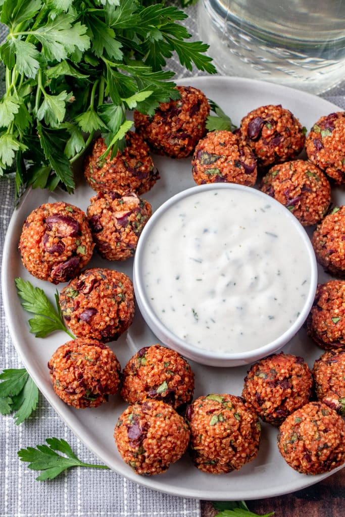 a plate of quinoa pizza balls with yogurt ranch dip in the middle 