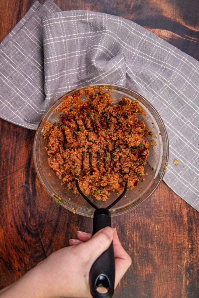 mashing ingredients together with a potato masher