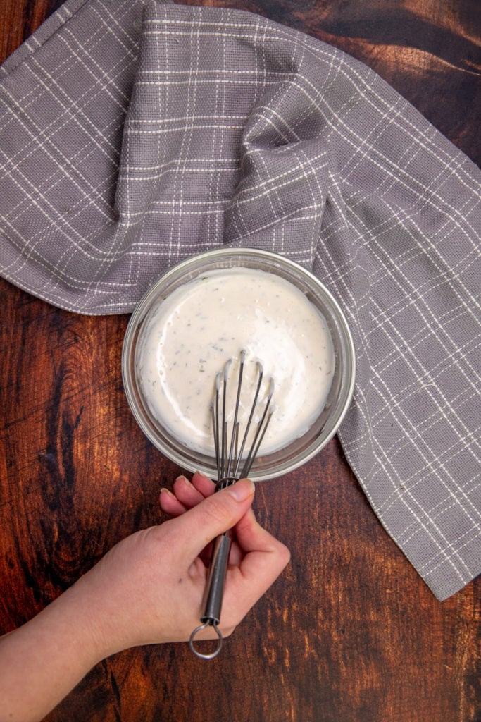 yogurt ranch dip in a bowl with a whisk