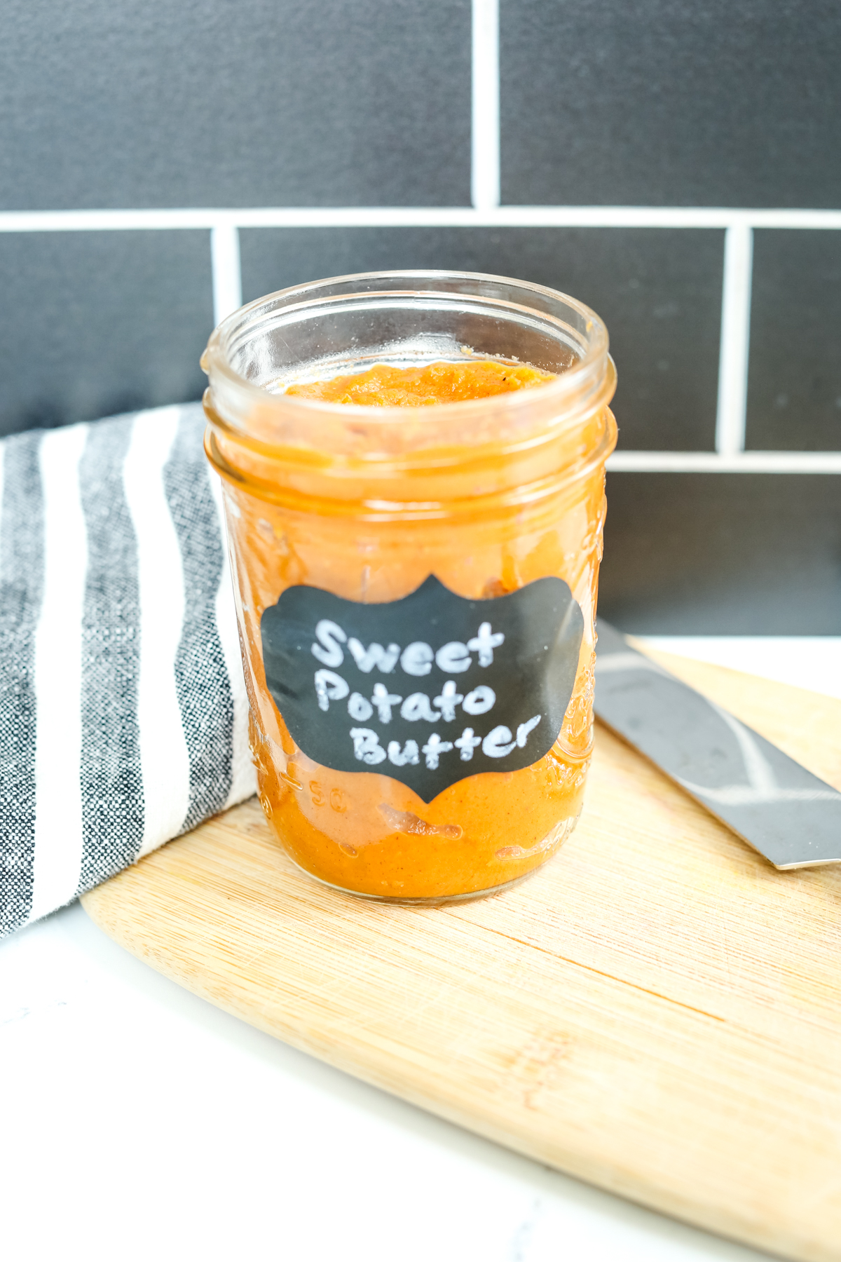 sweet potato butter in a mason jar with a black label and white writing