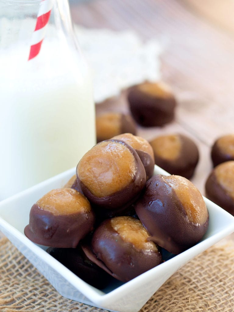 Healthy Buckeyes! This Skinny Buckeye recipe is a healthy candy recipe that is made using chickpeas! Chickpea Buckeyes?! YES. Trust me--your whole family will LOVE this healthy dessert naturally sweetened with honey. These healthy chocolate covered peanut butter balls are my favorite for both football season food and a healthy holiday treat!