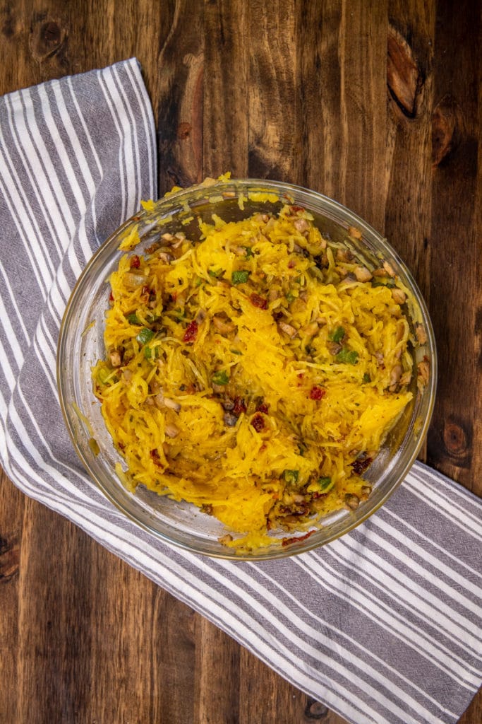 the mixture of the stuffed spaghetti squash all mixed together in a glass bowl