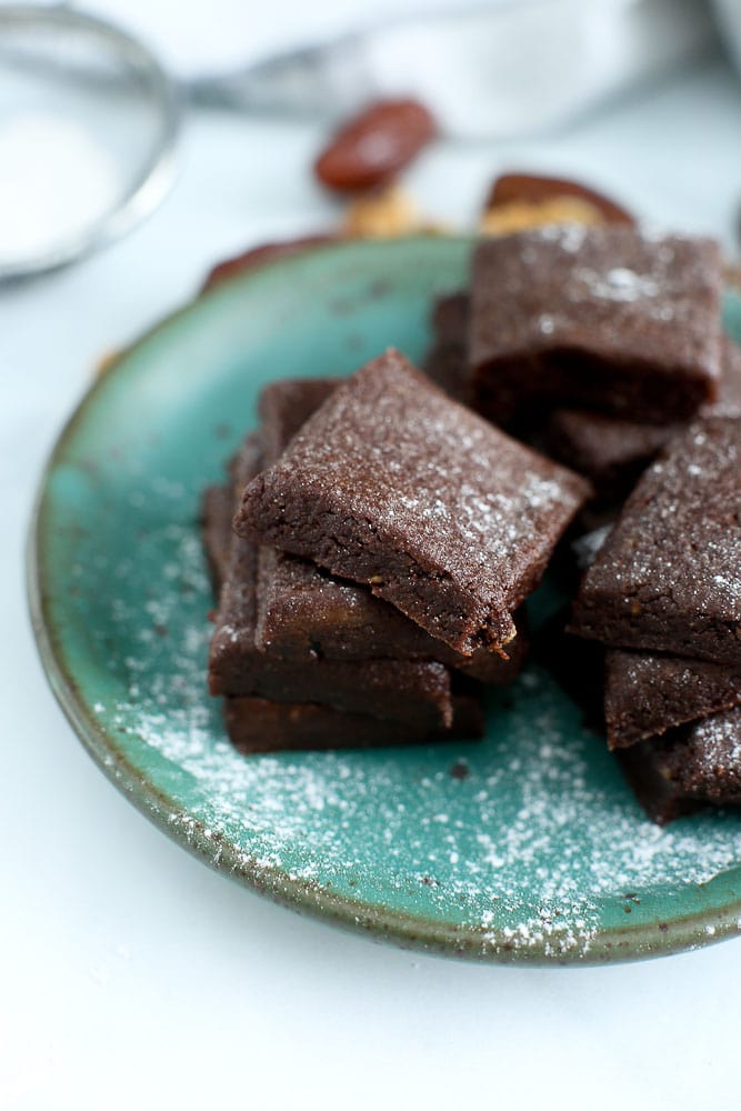 clean eating no bake brownies recipe--a pile of brownies on a green plate