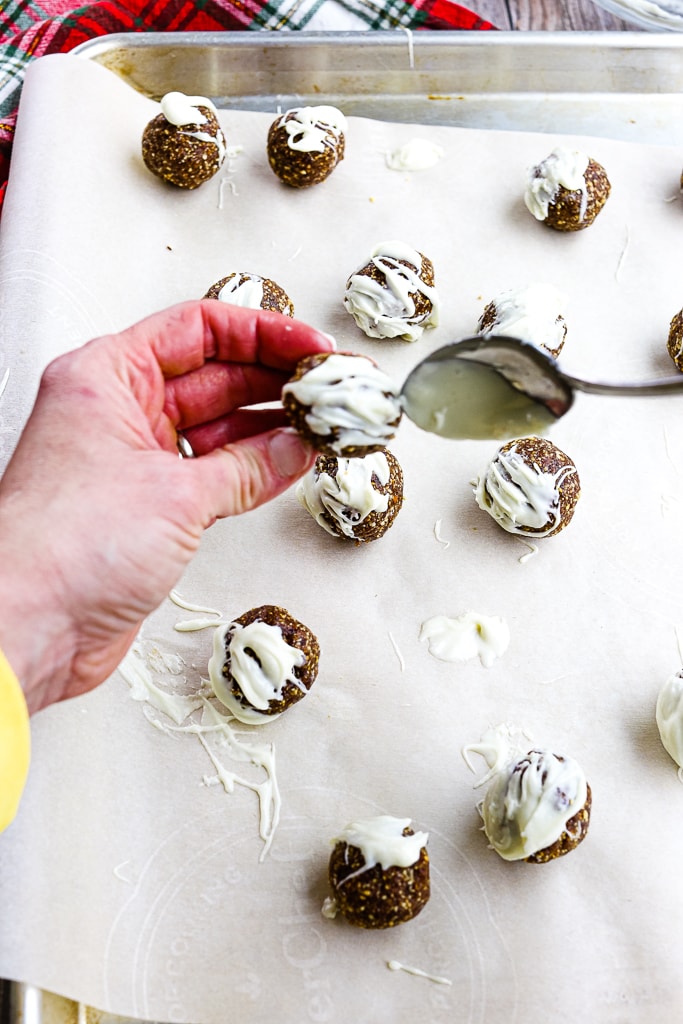 adding melted white chocolate to the energy balls
