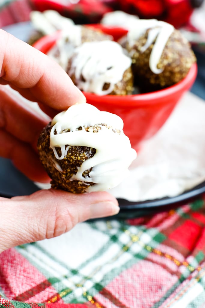 a close up shot of a no bake gingerbread cookie energy ball with white chocolate