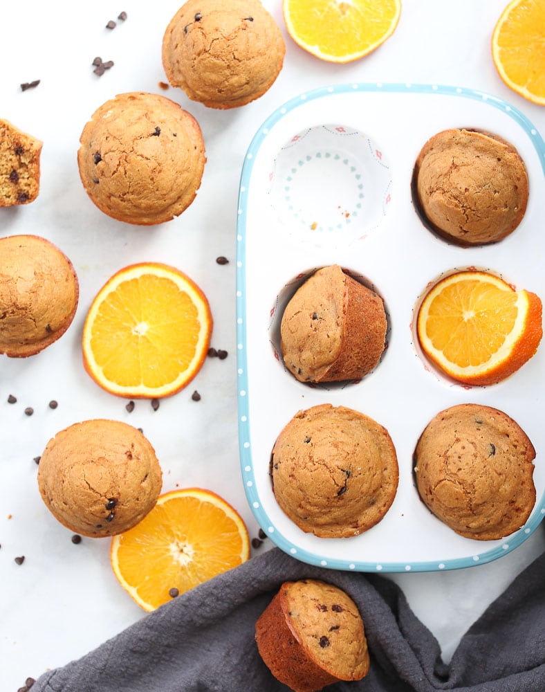 Orange Chocolate Chip Muffins-on a table with orange slices and chocolate chips healthy muffin recipeOrange Chocolate Chip Muffins-on a table with orange slices and chocolate chips healthy muffin recipe