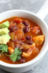 Pumpkin Chicken Chili recipe in a bowl with avocado and cilantro