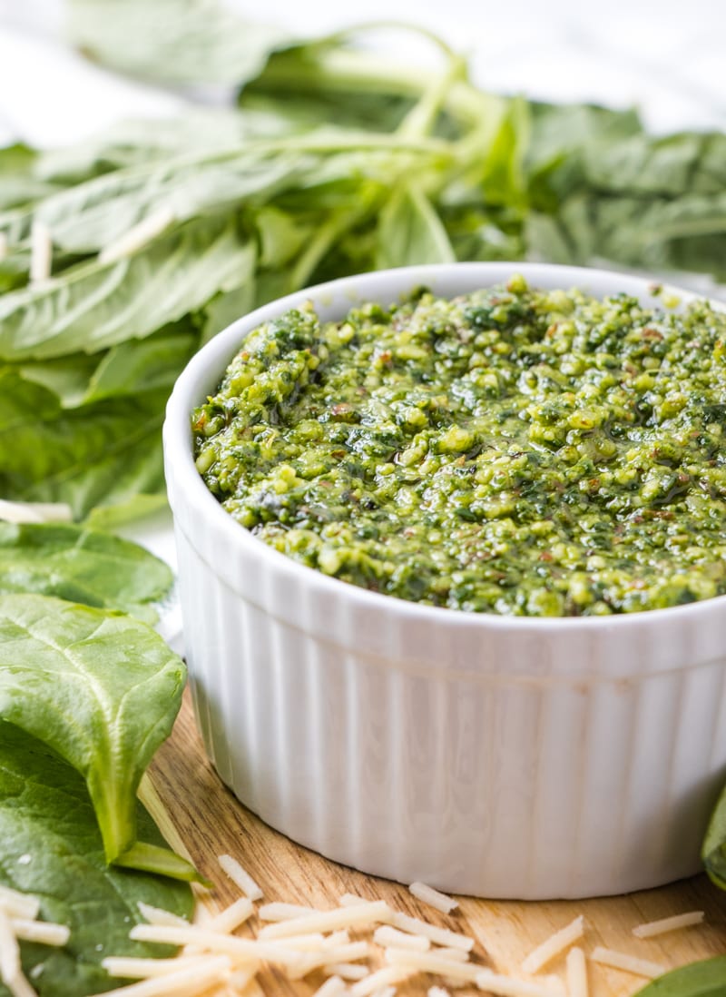 Spinach Pesto in a white bowl with fresh basil