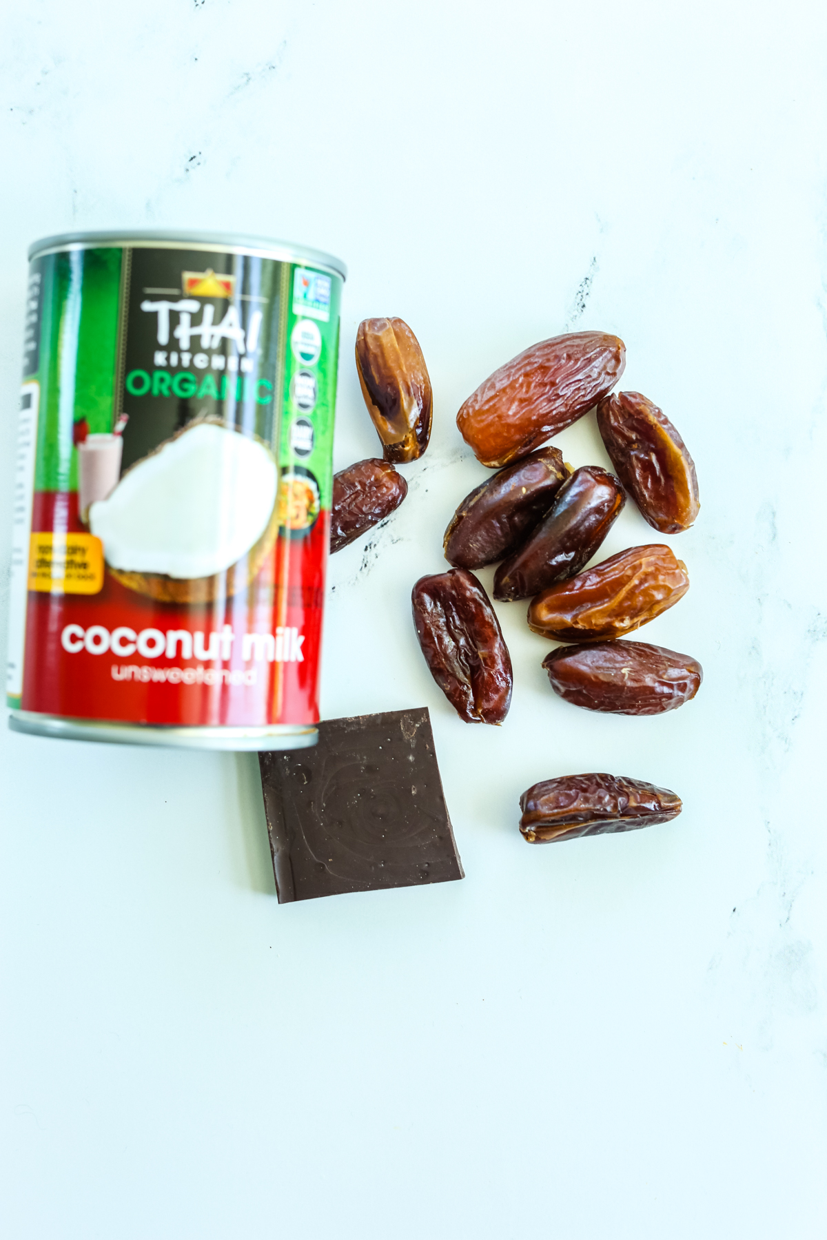 coconut milk can, dates, and a square of chocolate