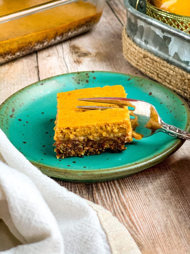 a pumpkin pie bar on a plate with a fork going in.