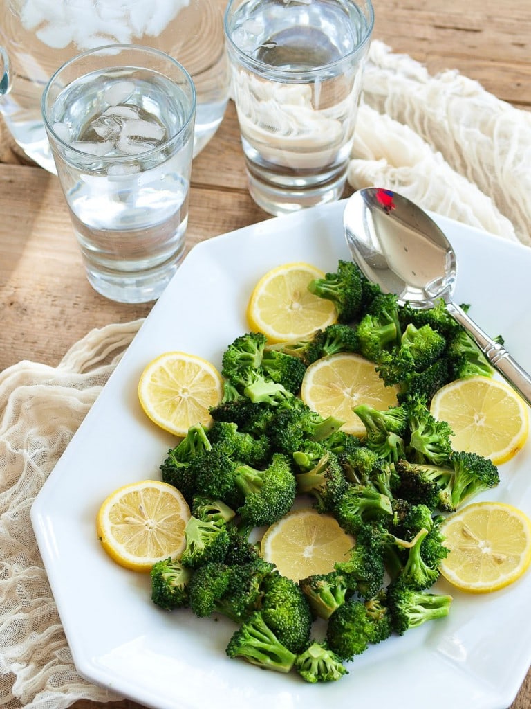 a side dish of broccoli and lemon on a plate