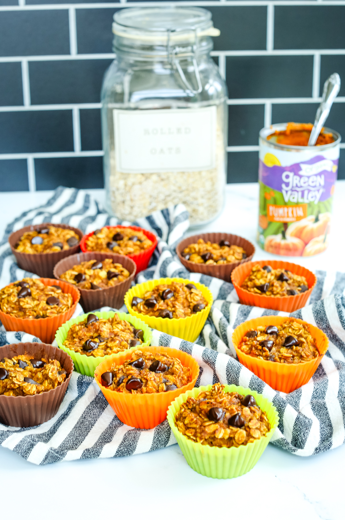 Pumpkin Oatmeal Muffins on a counter in colorful silicone baking cups with a striped napkin