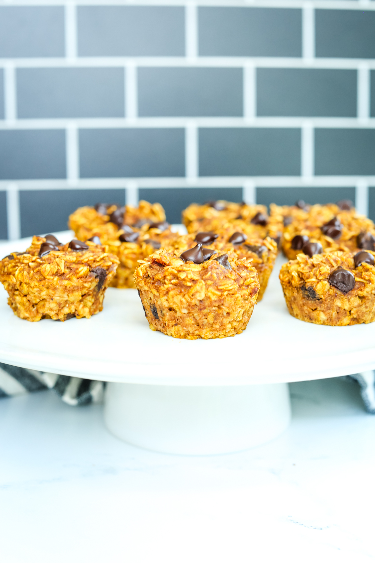 Pumpkin Oatmeal Muffins with chocolate chips on a white cake stand