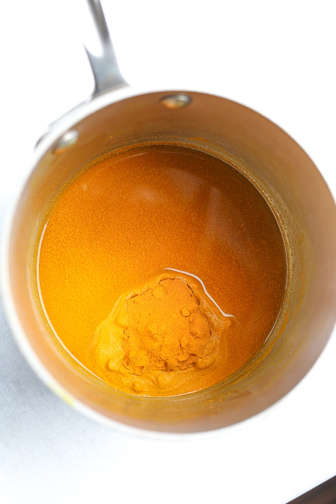 turmeric powder and water in a pan before combining to make turmeric paste