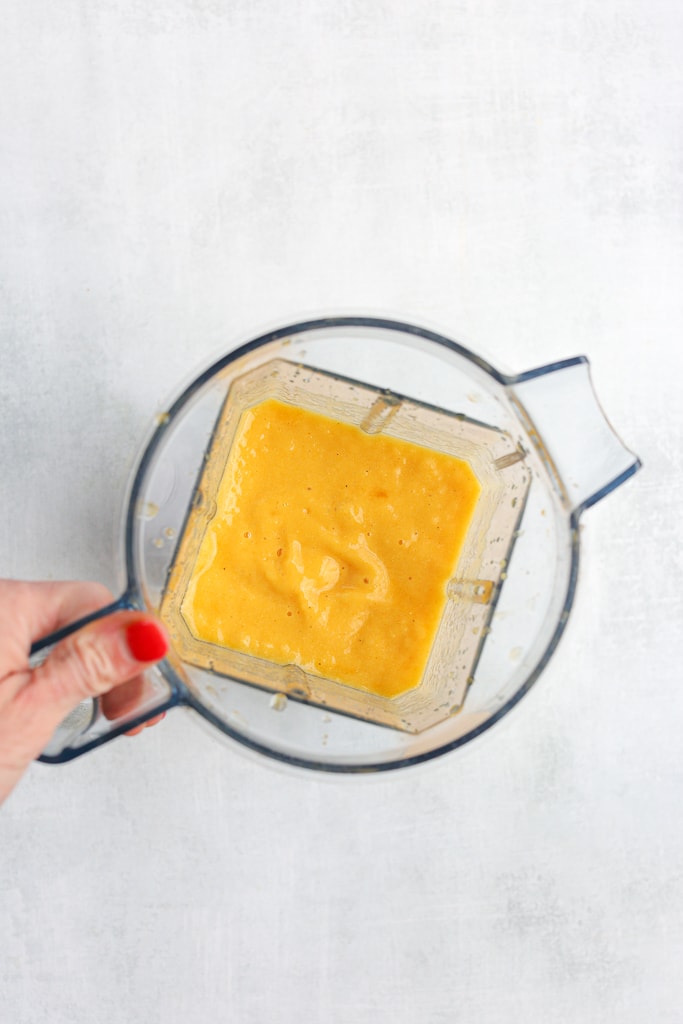 overhead shot of golden-colored smoothie creamy in the blender 