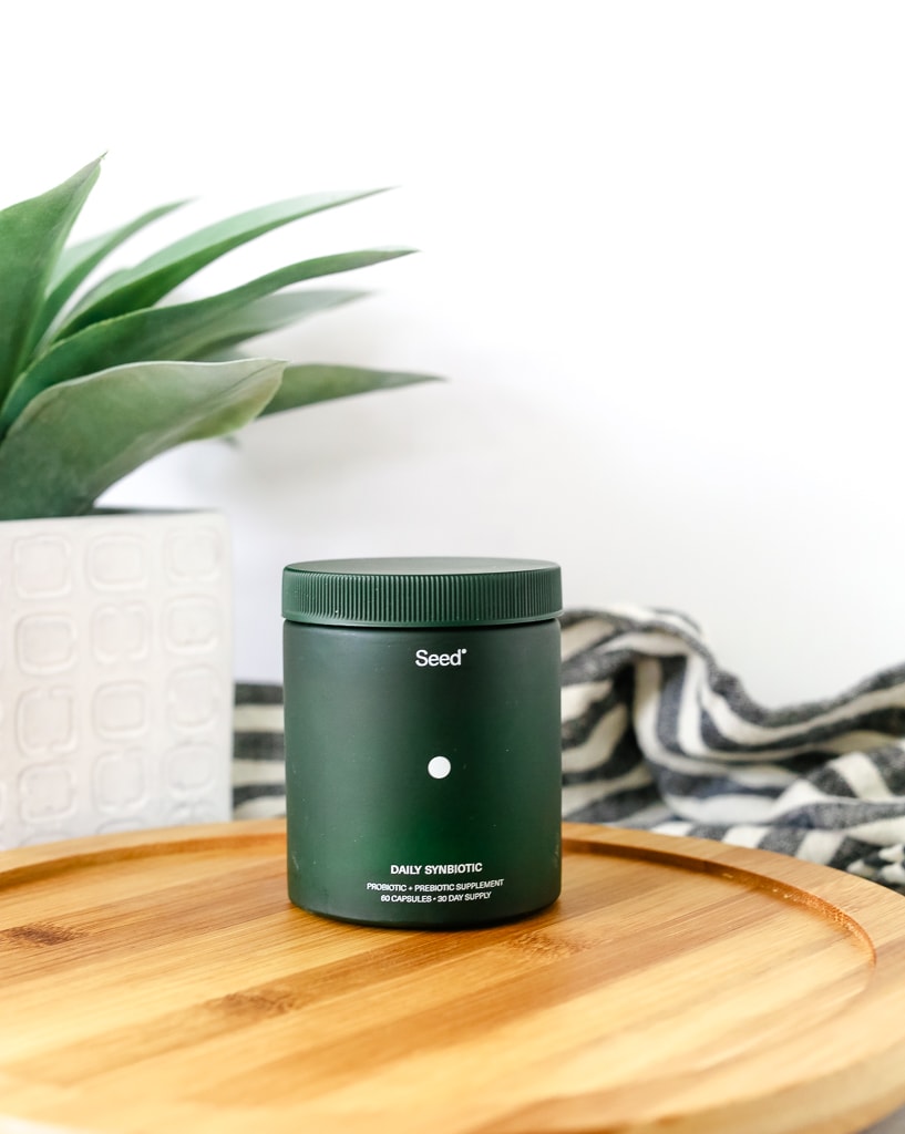 a black bottle with the name seed on the front with a plant in the background