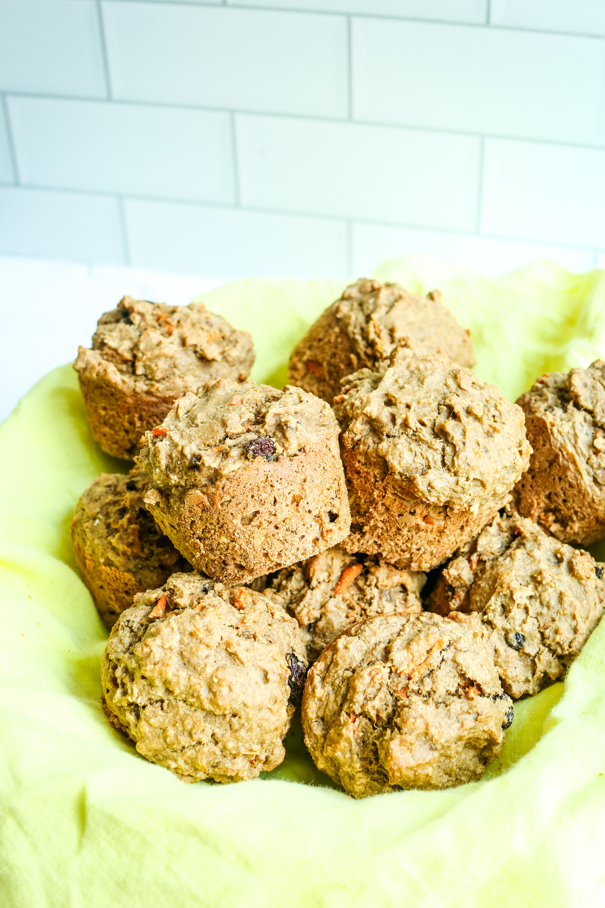 Carrot Cake Muffins in a bowl with a yellow napkin