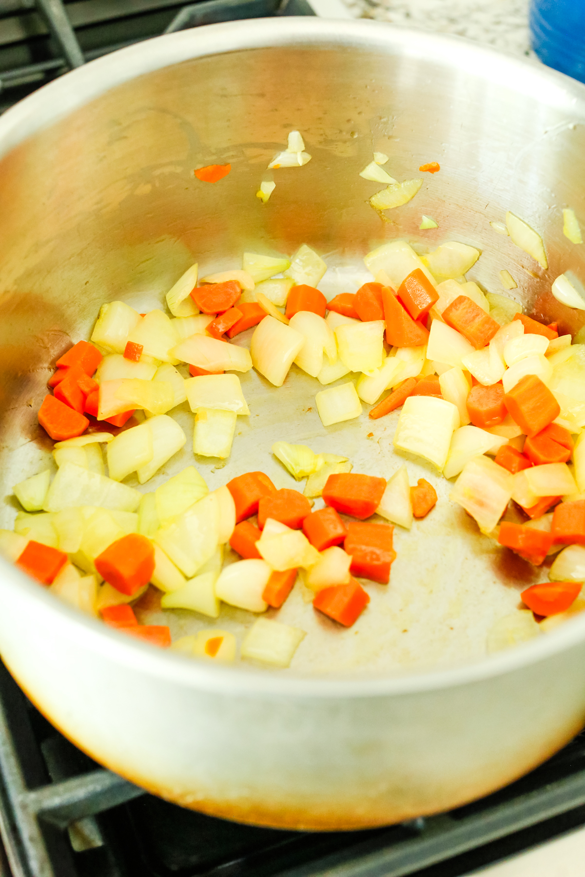 onions and carrots sautéing in a large stock pot