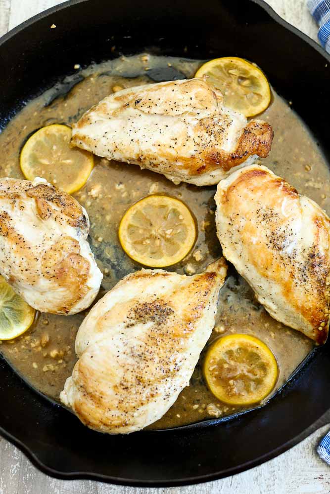 chicken with lemons and sauce in a skillet