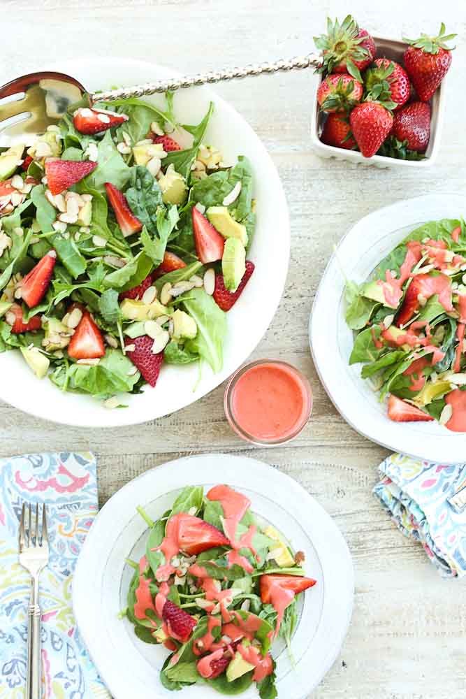 Strawberry Spinach Salad with Avocado and Strawberry Vinaigrette dressing set up on table