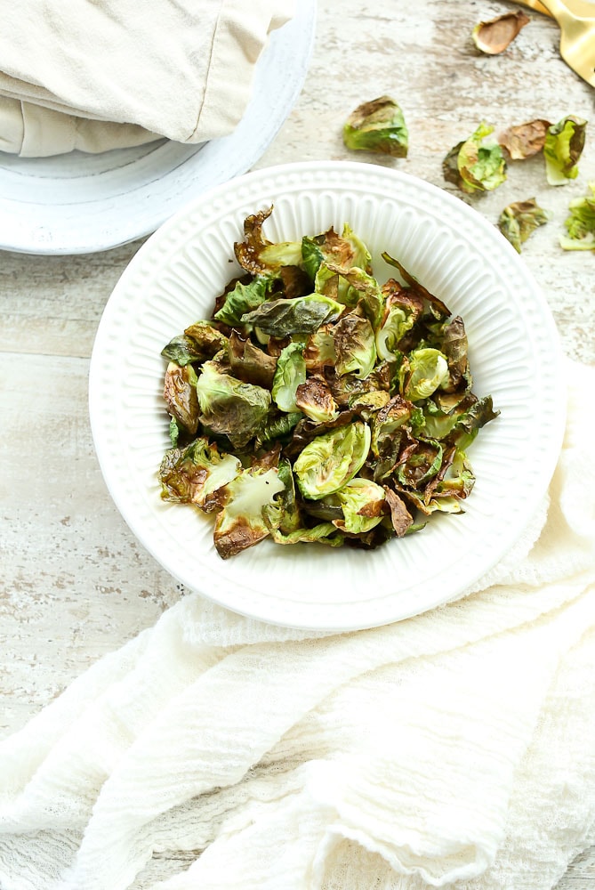 Crispy Brussels Sprouts Chips on the table in a bowlCrispy Brussels Sprouts Chips on the table in a bowl