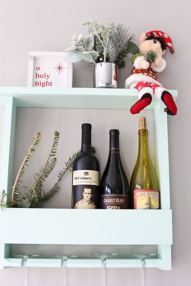 Dingle the original elf on the shelf--next to our wine bottles