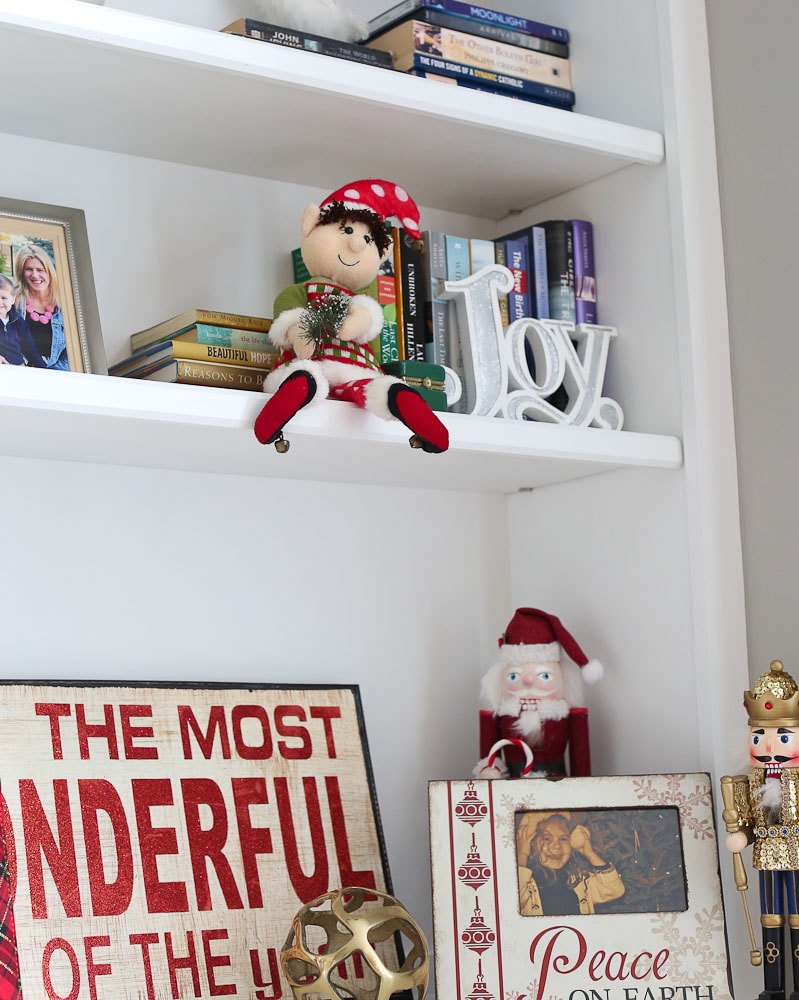 Dingle the original elf on the shelf-sitting on a bookshelf