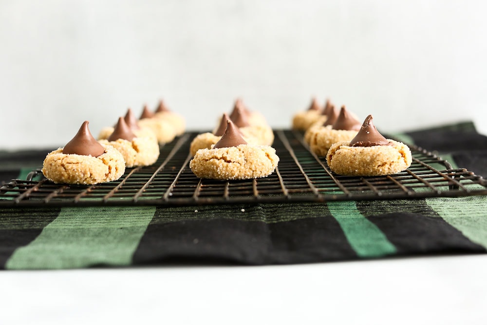 Gluten Free Peanut Butter Blossoms Cookies on a cooling rack side angle