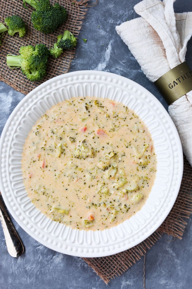 Instant Pot Broccoli Cheese Soup recipe in white bowl with cream napkin