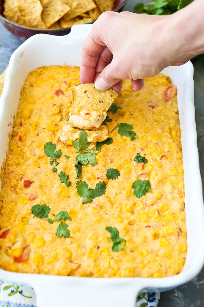 Hot Corn Dip Recipe the whole dish taking a scoop with a chip