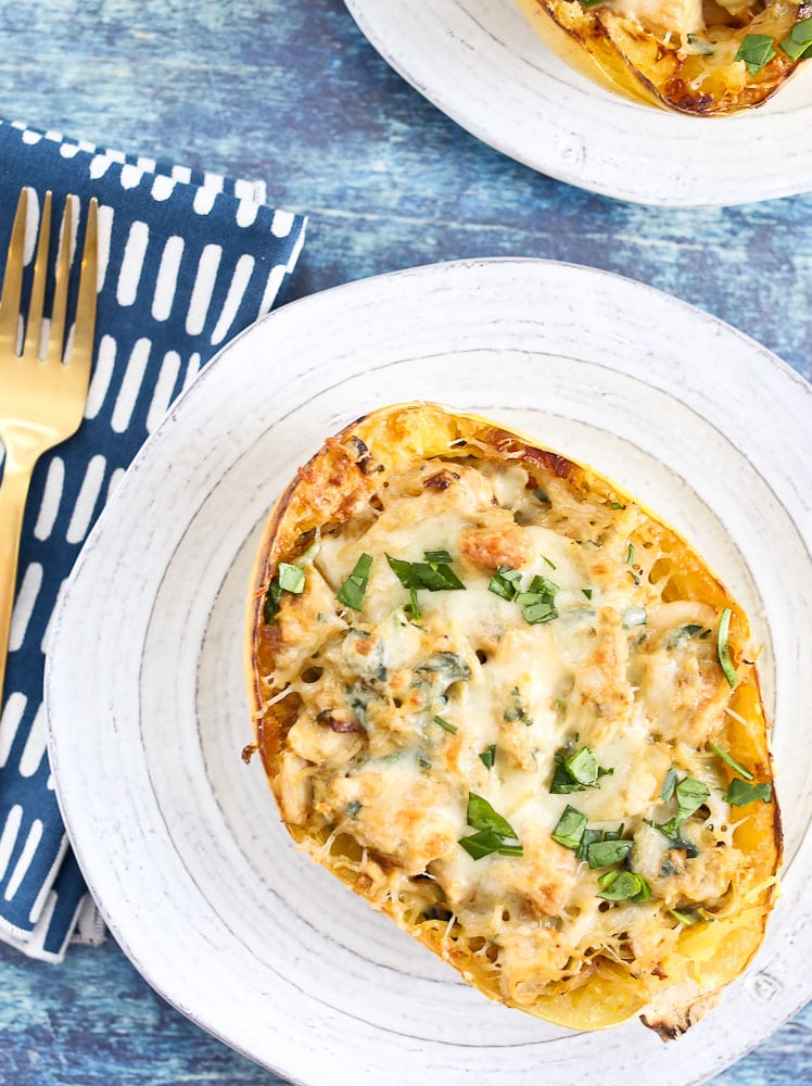 Spinach Artichoke Stuffed Spaghetti Squash with Chicken recipe on a plate with a fork and napkin