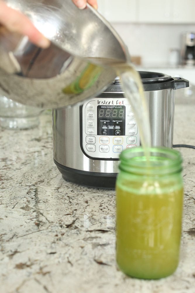 Instant Pot Bone Broth-pouring the broth into a mason jar