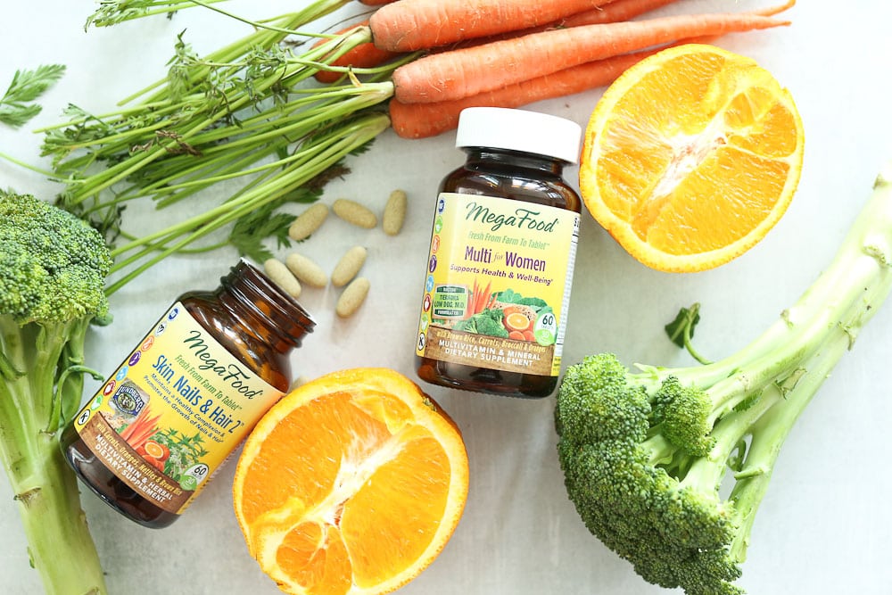 Best Multivitamin for women 2 bottles with whole foods oranges broccoli and carrots