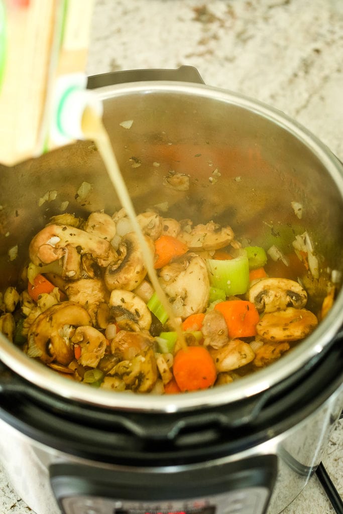 pouring the stock into nstant Pot Vegetable Soup with Beans recipe