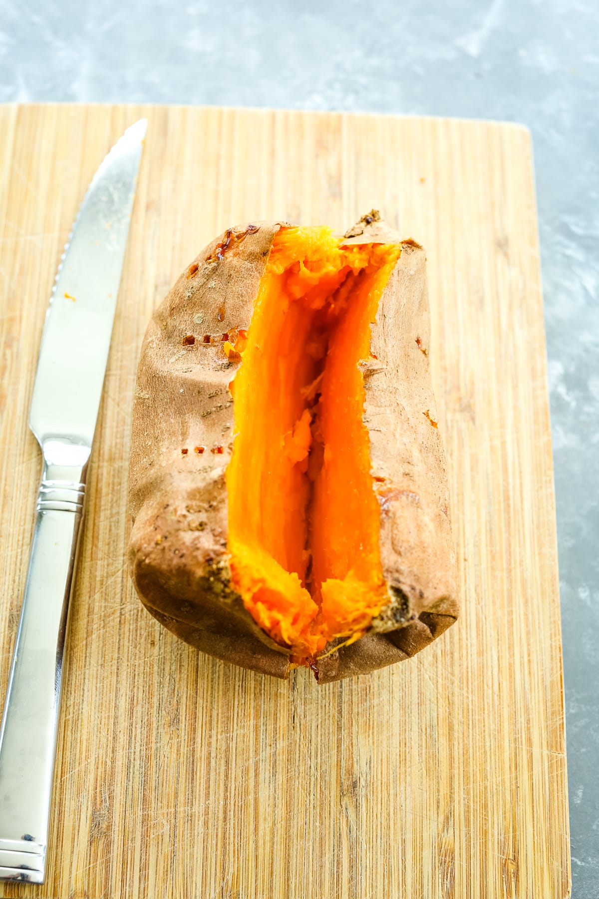 a sweet potato on a cutting board split open