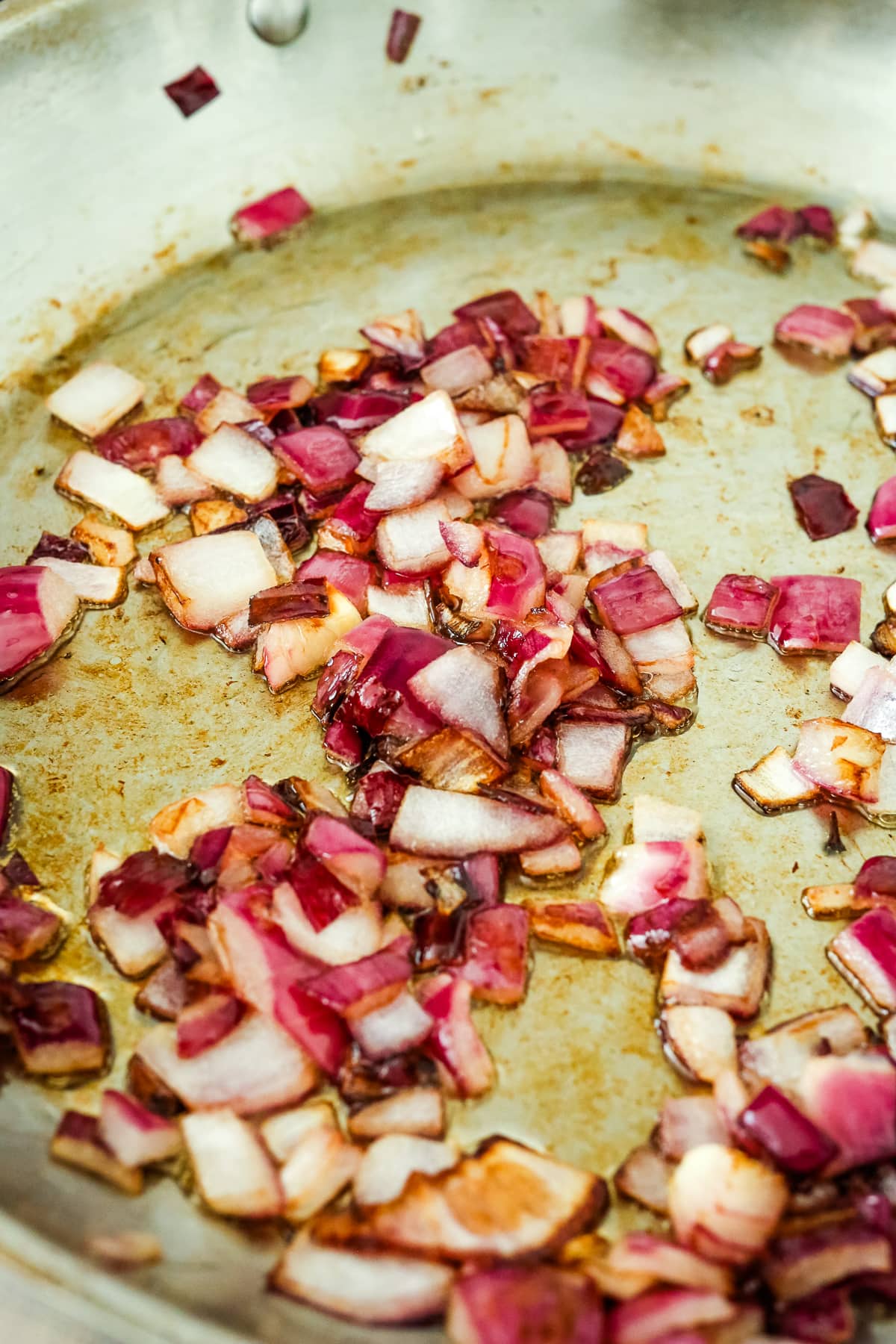 cooked, chopped red onion in a pan