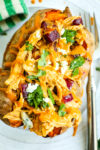 close up photo of Buffalo chicken Stuffed Sweet Potato with cilantro and extra buffalo sauce