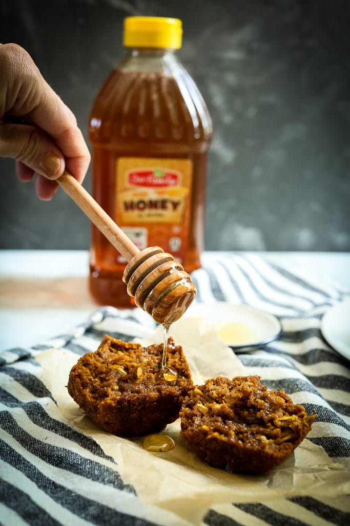 Gluten-Free Pumpkin Muffins Recipe drizzling honey on the muffin