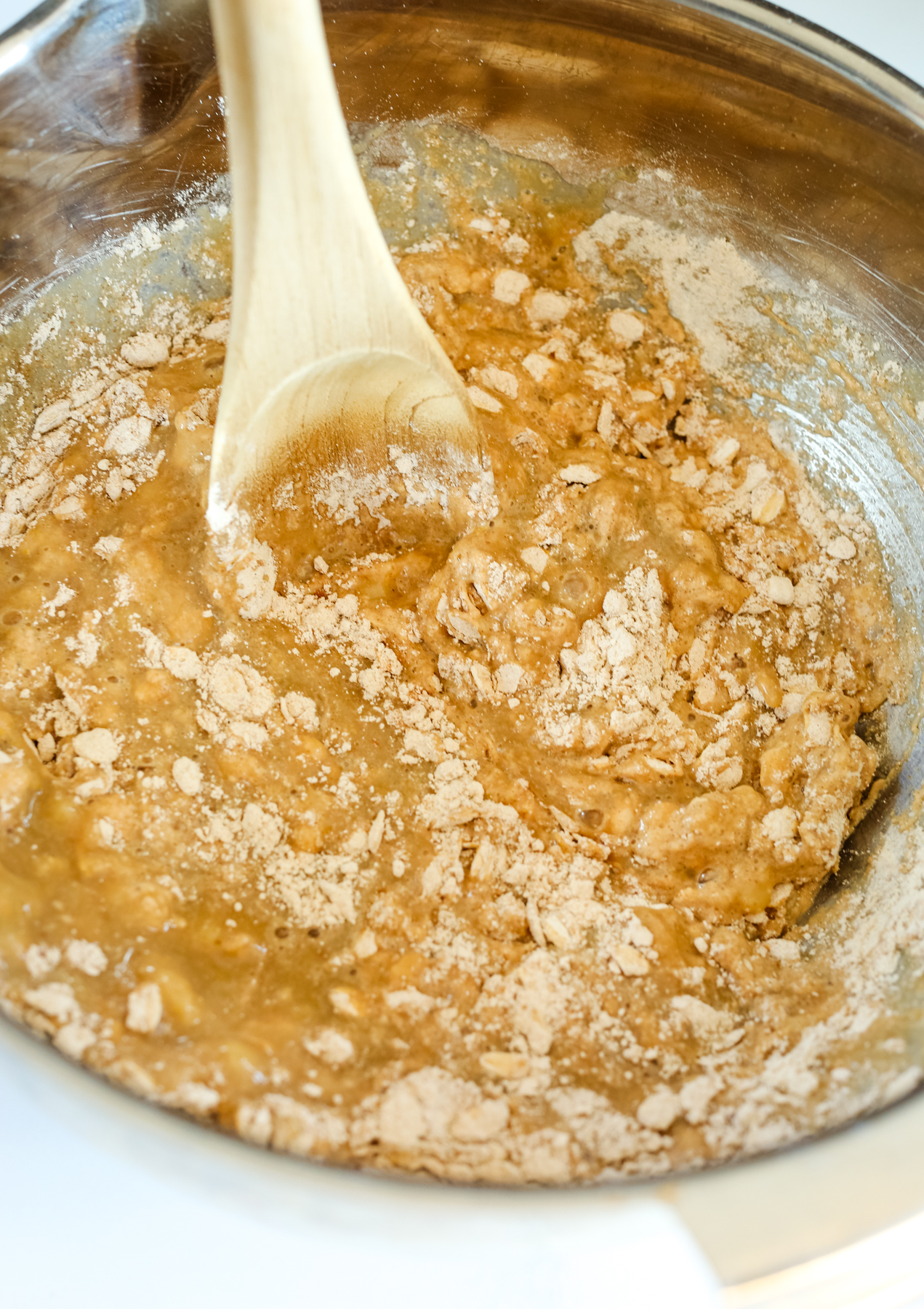 combining the dry and wet ingredients in a bowl with a wooden spoon