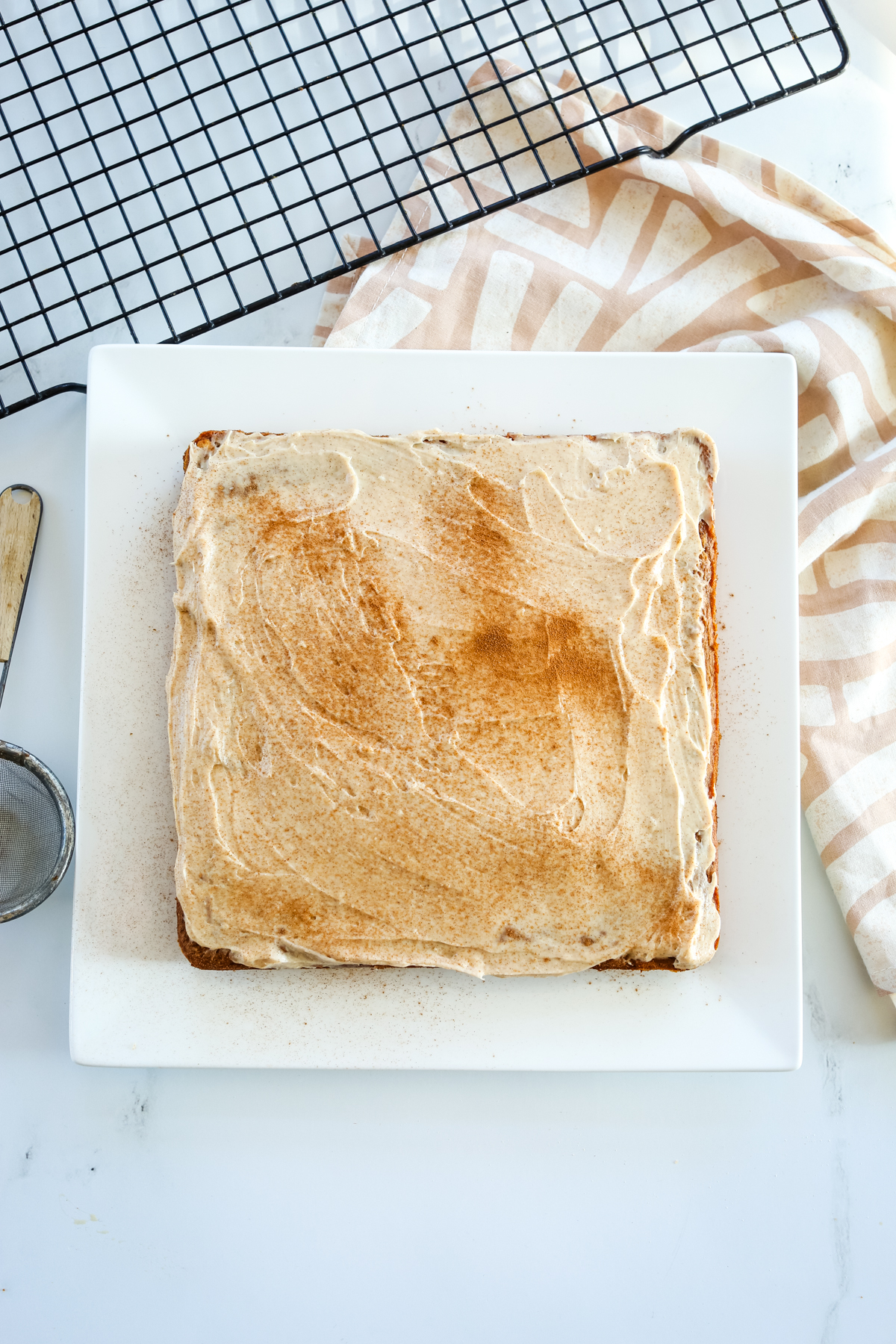 overhead shot of apple pear cake with cream cheese frosting and cinnamon sprinkled on top