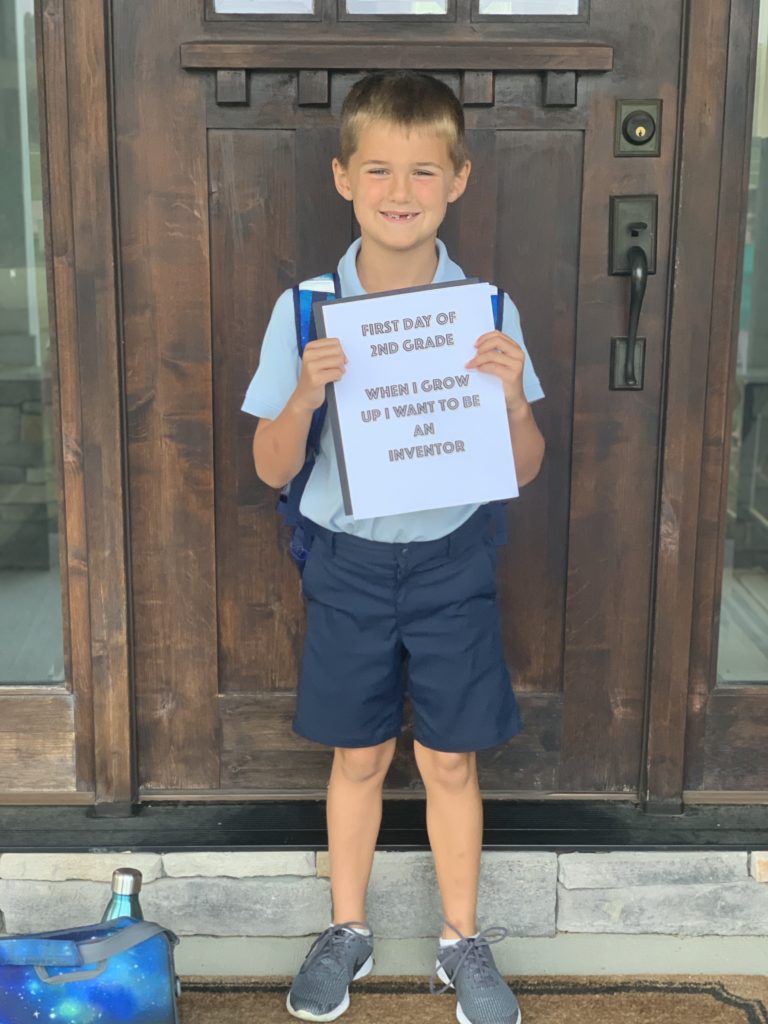Luke Dawson holding a first day of school sign that says he wants to be an inventor